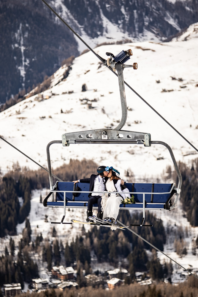 Fotografie sposi sugli sci, matrimonio in alta montagna sulla neve.